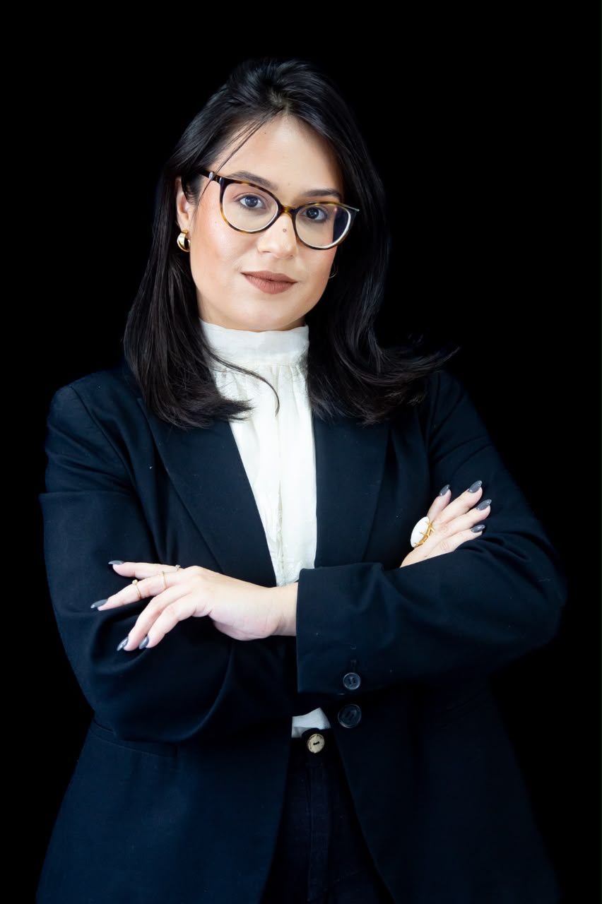 Fotografia corporativa da advogada Thais de Castro, de óculos e blazer preto com braços cruzados, especialista em Direito Civil e Recuperação de Crédito.